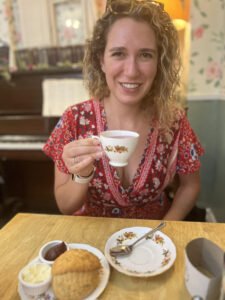 Alexandra sitting at a table drinking tea