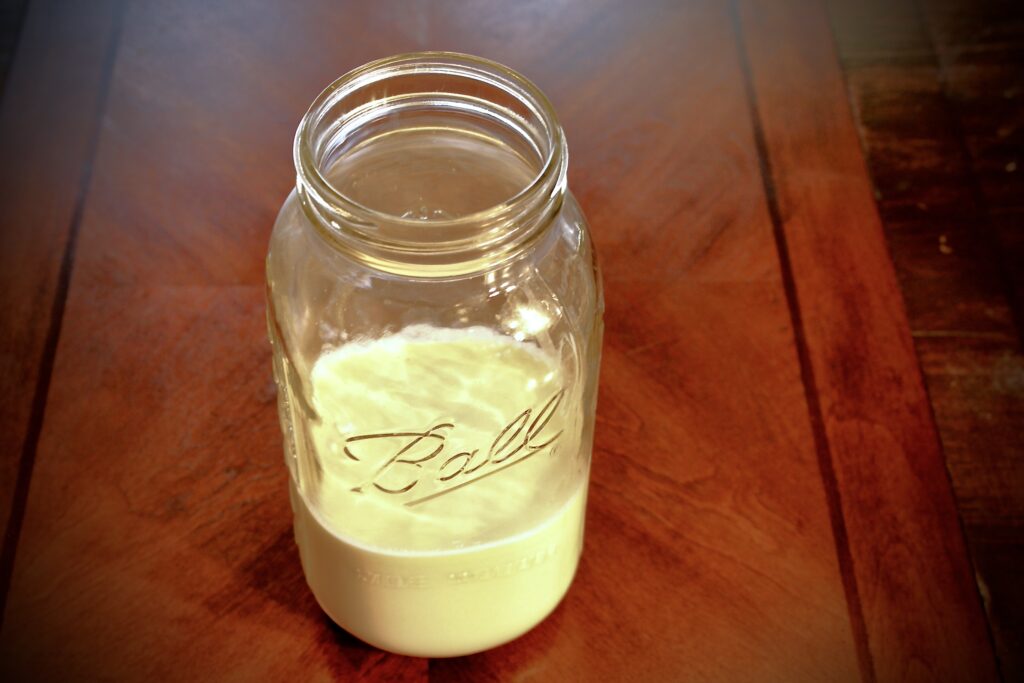 Jar of milk kefir sitting on a table